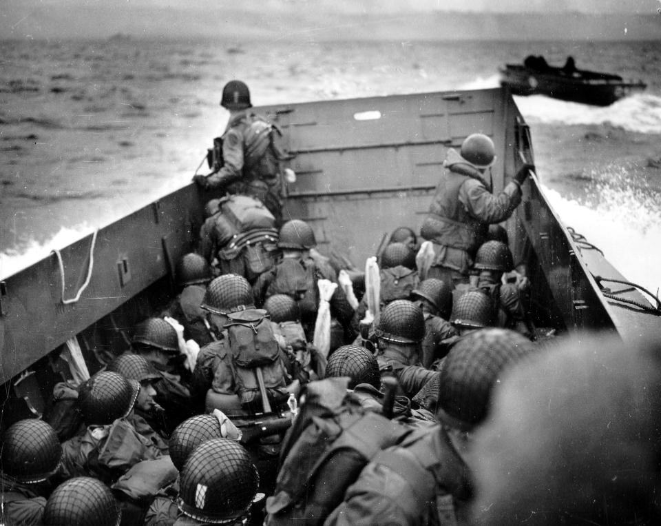 Troops crouch inside an landing, craft, vehicle, personnel boat, or Higgins boat, just before landing on Omaha Beach on D-Day.