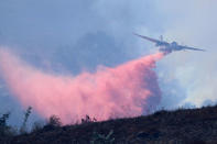 Water bombers drop fire retardant as they work to protect a Sullivan Middle School from a fast moving wild fire in Bonsall, California, U.S., December 7, 2017. REUTERS/Mike Blake