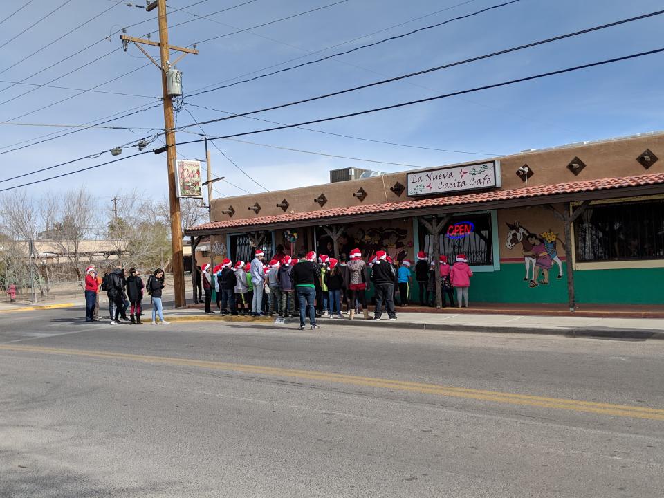 Children with the Weed and Seed program sing carols for the owners of La Nueva Casita Café to thank them for help with an enchilada fundraiser.