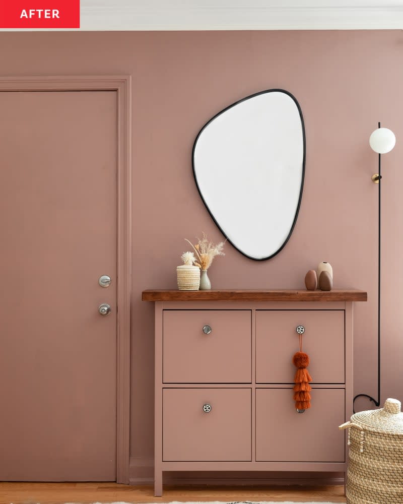 Monotone colored entryway with dresser for storage and asymmetrical mirror mounted above.