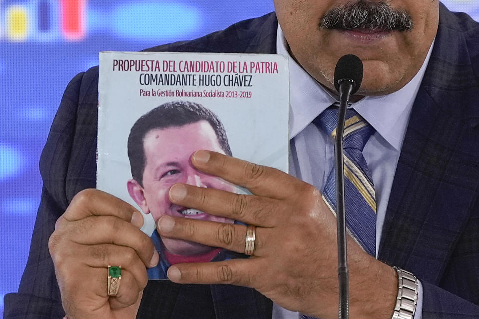 FILE - Venezuela's President Nicolas Maduro holds a book with an image of late Venezuelan president Hugo Chavez at a meeting with his ministers at the Humboldt Hotel on El Avila mountain in La Guaira, Venezuela, Sept. 21, 2023. (AP Photo/Matias Delacroix, File)