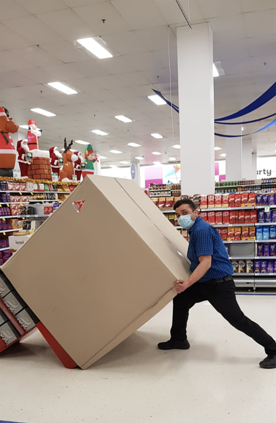 VB moving a large box inside a Coles store. 