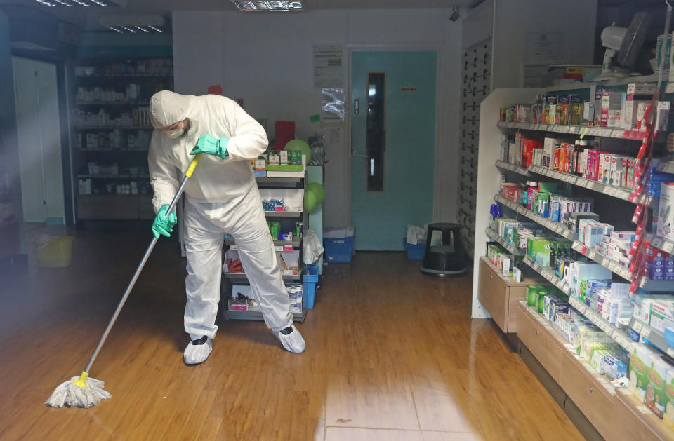 A man in protective clothing cleaning the County Oak Medical Centre GP practice in Brighton which has been temporarily closed "because of an urgent operational health and safety reason", following reports a member of staff there was one of those infected with coronavirus.