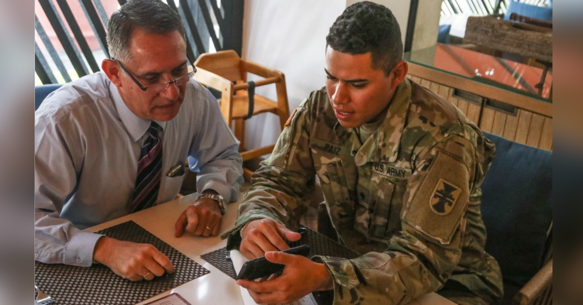 soldier looks at cell phone with his dad