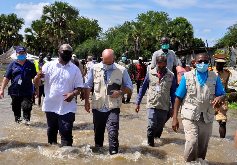 Alain Noudehou, UN Humanitarian Coordinator in South Sudan, and Matthew HollingWorth, the Country Director of World Food Program (WFP), wade through flood water, in Duk padiet county of Jonglei State