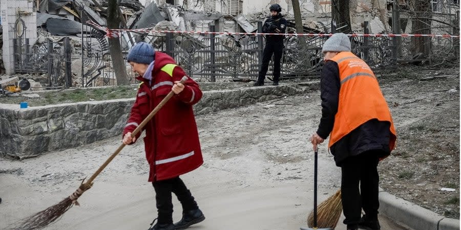People clean the street after the Russian attack on Kyiv