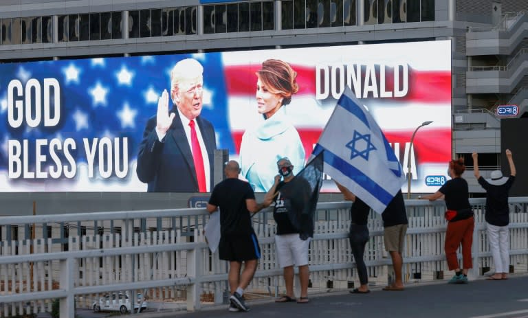 Donald Trump y su esposa Melania en una pantalla en Tel Aviv, el 3 de octubre de 2020 (JACK GUEZ)