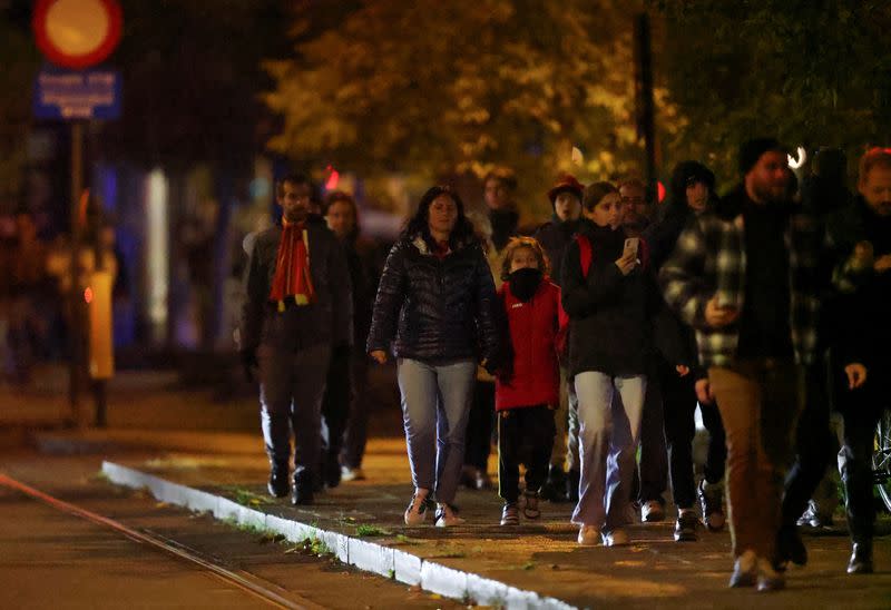 Gente camina fuera del estadio Rey Balduino después de que el partido entre Bélgica y Suecia fuera suspendido tras un tiroteo en Bruselas, Bélgica