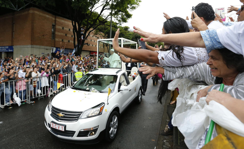 People wave to Pope Francis as he passes by in his popemobile in Medellin, Colombia, Saturday, Sept. 9, 2017. (AP Photo/Fernando Vergara)