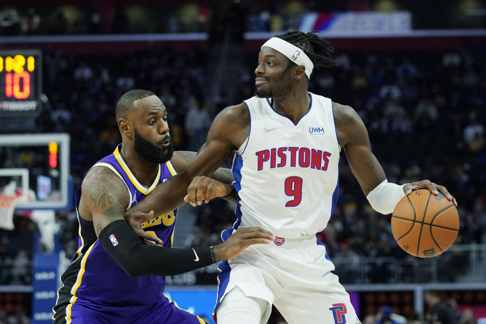 Detroit Pistons forward Jerami Grant (9) is defended by Los Angeles Lakers forward LeBron James (6) during the first half of an NBA basketball game, Sunday, Nov. 21, 2021, in Detroit. (AP Photo/Carlos Osorio)