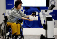 Toyota's Human Support Robot (HSR) delivers a basket to a woman in a wheelchair at a demonstration of Tokyo 2020 Robot Project for Tokyo 2020 Olympic Games in Tokyo, Japan, March 15, 2019. REUTERS/Kim Kyung-hoon