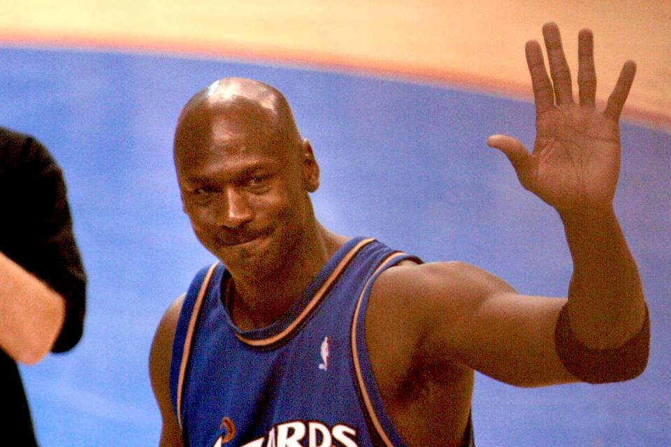 Michael Jordan waves as he walks off the court at the end of the Washington Wizards' game against the Philadelphia 76ers on April 16, 2003, in Philadelphia. It was Jordan's last NBA game.