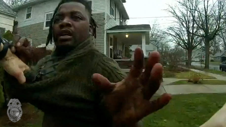 A Grand Rapids Police officer grasps the shirt of Patrick Lyoya.