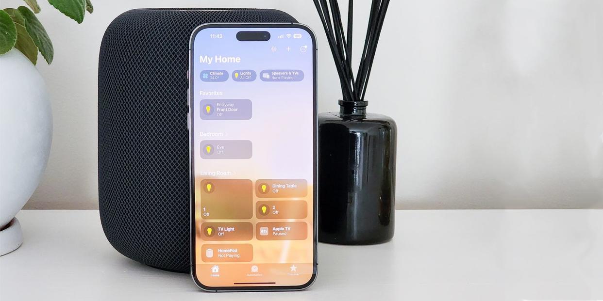 apple homepod on a counter with an iphone showing the homepod app