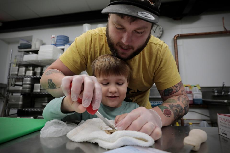 Joshua Lemaire teaches his son Sam Lemaire, 4, how to shuck an oyster in the newly opened Union Flats restaurant at 37 Union Street in downtown New Bedford.