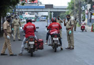 Policemen check the credentials of food delivery personnel during a lockdown imposed to curb the spread of coronavirus in Kochi, Kerala state, India, Saturday, May 8, 2021. Kerala, which emerged as a blueprint for tackling the pandemic last year, began a lockdown on Saturday. (AP Photo/R S Iyer)