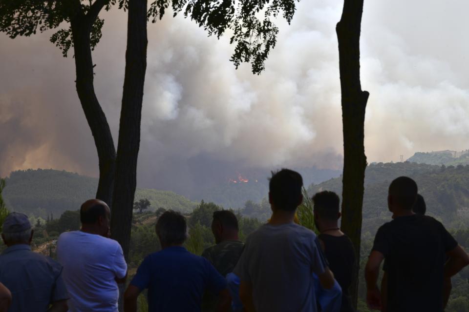 Look residents watch the wildfire near Olympia town, western Greece, Thursday, Aug. 5, 2021. Wildfires rekindled outside Athens and forced more evacuations around southern Greece Thursday as weather conditions worsened and firefighters in a round-the-clock battle stopped the flames just outside the birthplace of the ancient Olympics. (Giannis Spyrounis/ilialive.gr via AP)