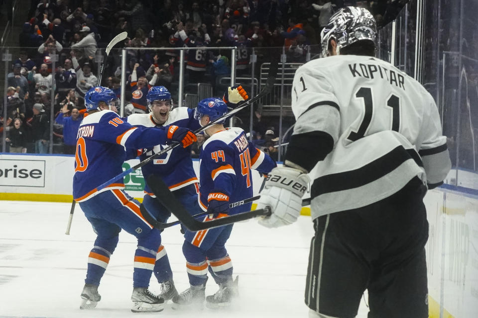 New York Islanders' Jean-Gabriel Pageau, third from left, joins teammates after scoring the winning goal in overtime against the Los Angeles Kings in an NHL hockey game, Saturday, Dec. 9, 2023, in Elmont, N.Y. (AP Photo/Bebeto Matthews)