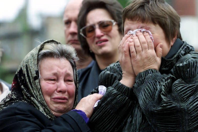 Relatives of more than 100 people who were killed in the September 13, 1999, bombing in an eight-story apartment building, cry at the site of explosion in Moscow on September 13, 2000. File Photo by Maxim Marmur/UPI
