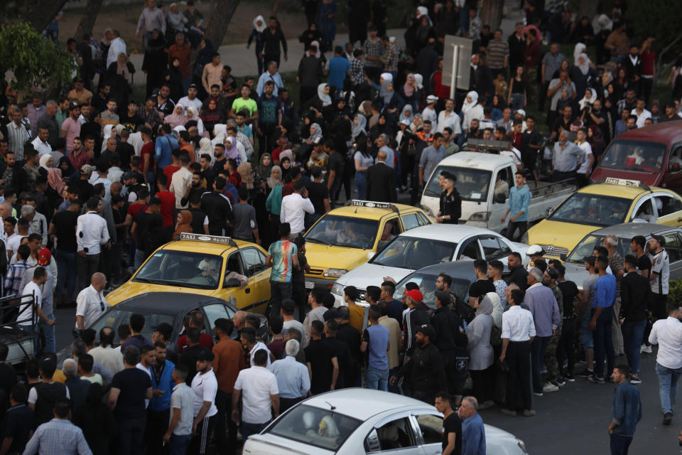 FILE - Dozens of Syrians wait at the President's Bridge in Damascus for relatives they hope would be among those released from prison May 3, 2022, on the second day of the Muslim Fitr holiday. A newly released video taken in 2013 showed blindfolded men who were thrown into a large pit and shot dead by Syrian agents, who then set the bodies on fire. The video stirs new fears over the fate of tens of thousands who went missing during Syria's long-running conflict and serves as a grim reminder of the war's unpunished massacres, just as similar atrocities take place in Ukraine. (AP Photo/Omar Sanadiki, File)