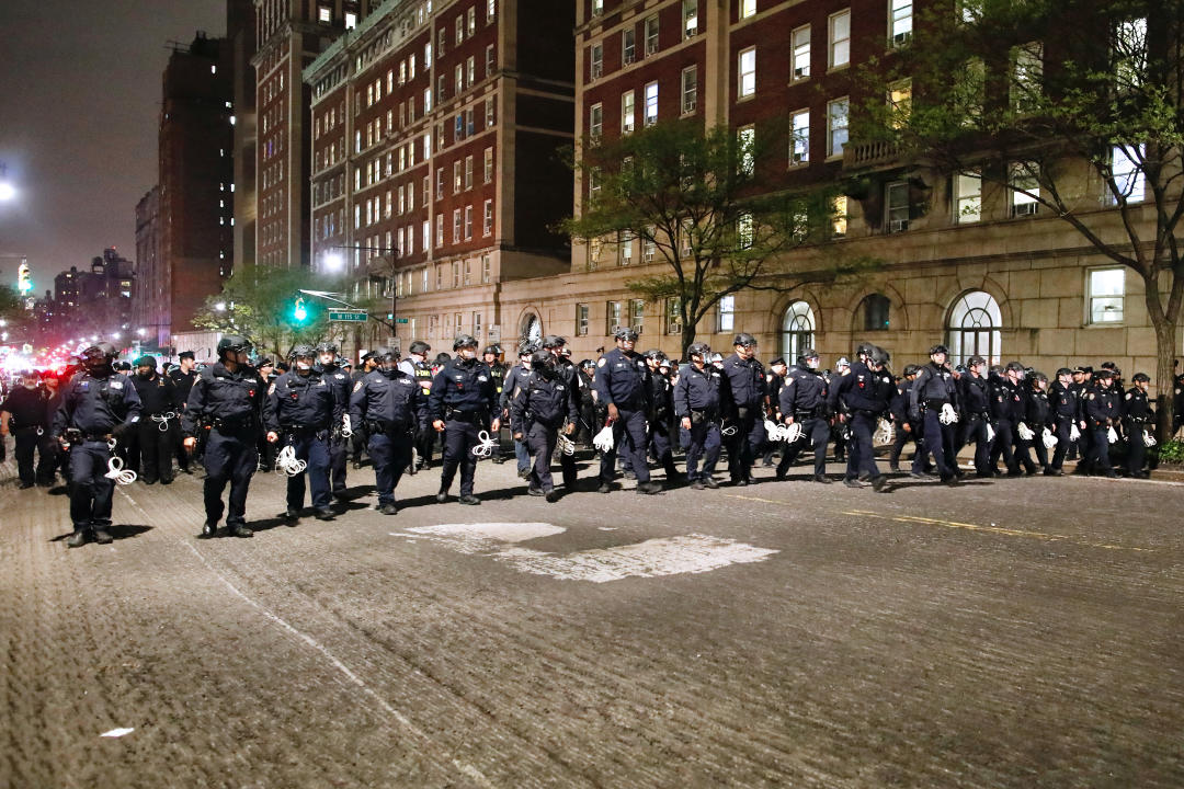 Rows of NYPD police officers in riot gear march onto Columbia University campus, where pro-Palestinian students are barricaded inside a building and have set up an encampment.