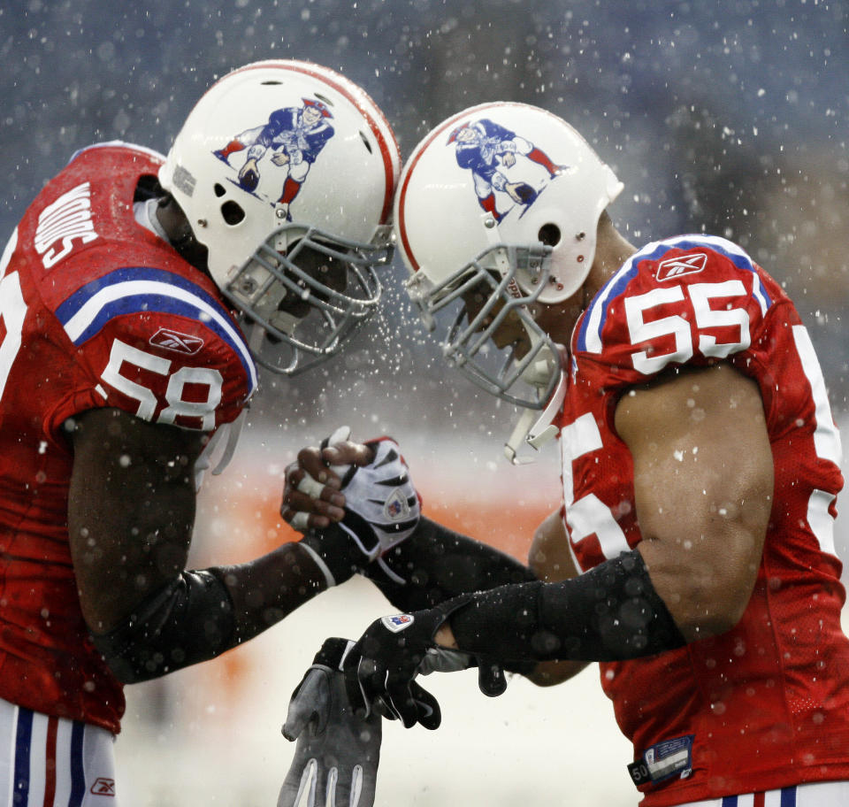 New England Patriots linebacker Junior Seau, right, butts heads with teammate linebacker Pierre Woods in the snow prior to an NFL football game against the Tennessee Titans at Gillette Stadium in Foxborough, Mass. Sunday, Oct. 18, 2009. (AP Photo/Winslow Townson)