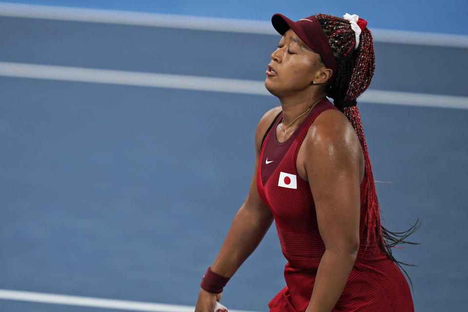 Naomi Osaka, of Japan, reacts after losing a point to Marketa Vondrousova, of the Czech Republic, during the third round of the tennis competition at the 2020 Summer Olympics, Tuesday, July 27, 2021, in Tokyo, Japan. (AP Photo/Seth Wenig)