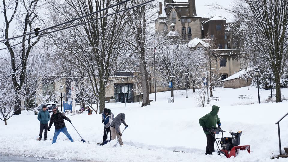 A crew clears snow from a sidewalk in Doylestown, Pennsylvania. - Matt Rourke/AP