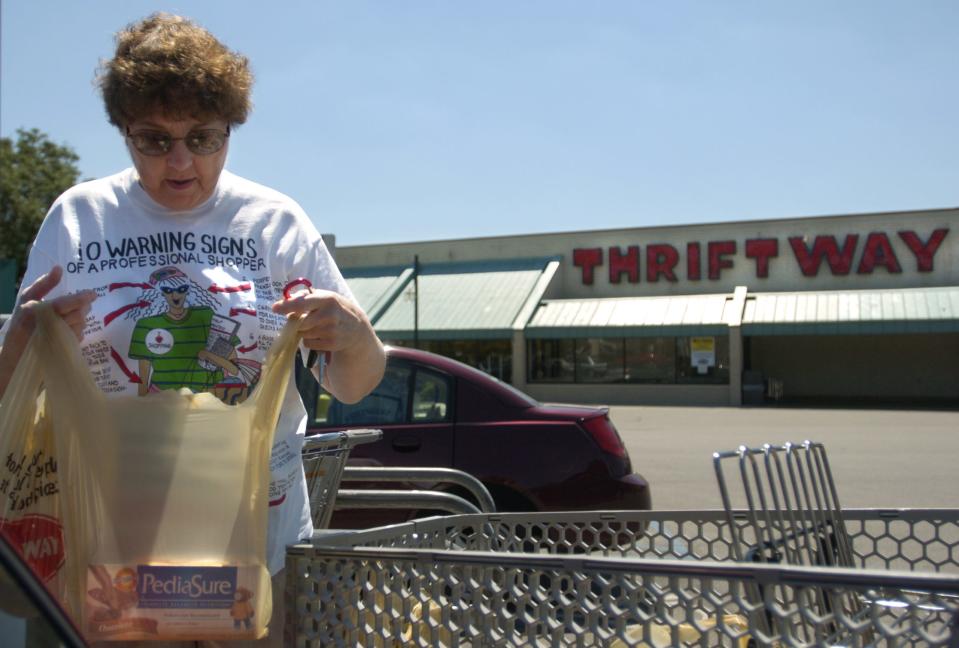 Virginia Newton of Norwood loads bags of groceries into her car at the Norwood Thriftway on the store's final day of business in 2004.