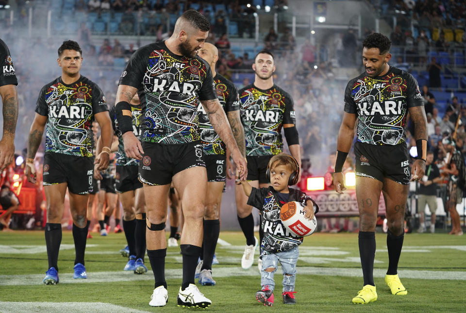 Quaden Bayles leads the Indigenous All Stars on to the field with captain Joel Thompson prior to the NRL Indigenous All-Stars vs. Maori Kiwis match at CBus Super Stadium on the Gold Coast. (Photo: ASSOCIATED PRESS)