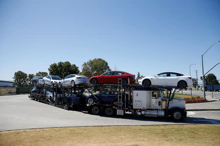 A car carrier trailer carries Tesla Model 3 electric sedans, is seen outside the Tesla factory in Fremont, California, U.S. June 22, 2018. REUTERS/Stephen Lam
