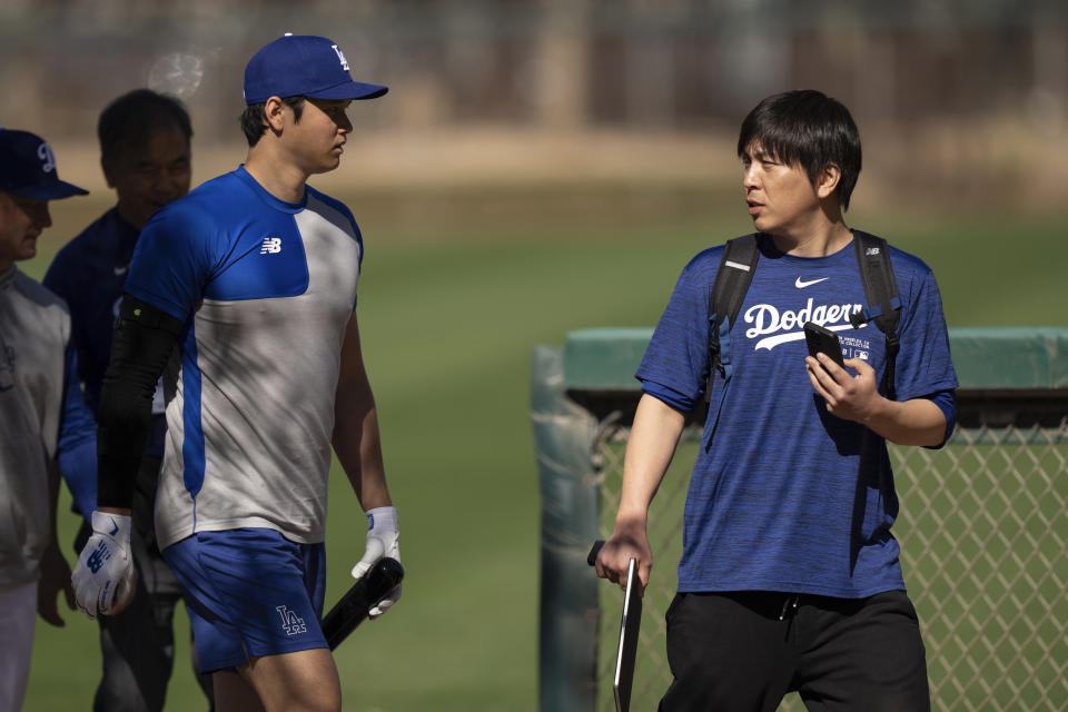 FILE - Los Angeles Dodgers' Shohei Ohtani walks with interpreter Ippei Mizuhara at batting practice during spring training baseball workouts in Phoenix on Feb. 12, 2024. Mizuhara has been fired by the Dodgers following allegations of illegal gambling and theft. (AP Photo/Carolyn Kaster,File)