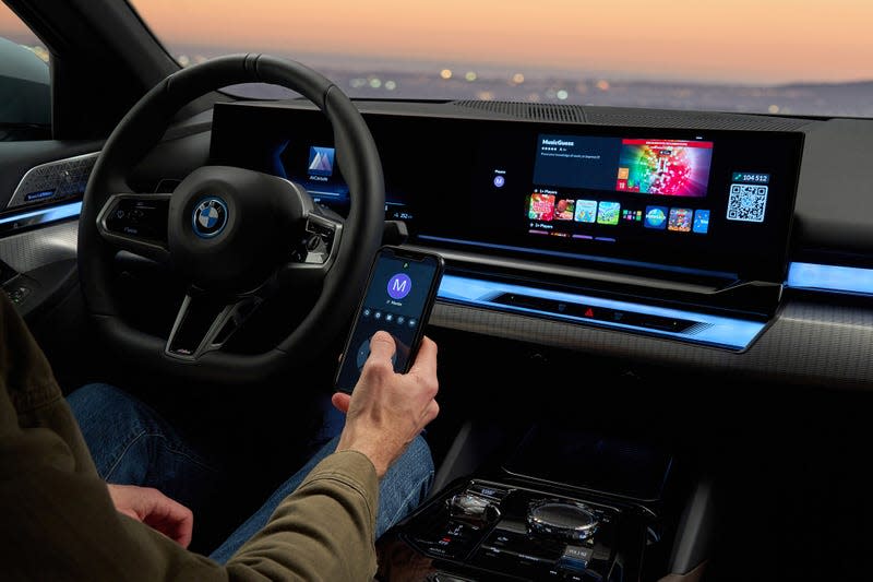 A passenger selects a video game on the 2024 BMW 5 Series display through AirConsole.