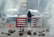 FILE - In this file photo dated Friday Jan. 14, 2011, a Tunisian riot police officer holds his weapon during riots in Tunis, Friday, Jan. 14, 2011. Tunisia's president declared a state of emergency and announced that he would fire his government as violent protests escalated Friday, with gunfire echoing in the North African country's usually calm capital and police lobbing tear gas at protesters. On Thursday Jan. 14, 2021, Tunisia commemorates 10 years since the flight into exile of its iron-fisted leader, Zine El Abidine Ben Ali, pushed from power in a popular revolt that foreshadowed the so-called Arab Spring. (AP Photo/Hedi Ben Salem)