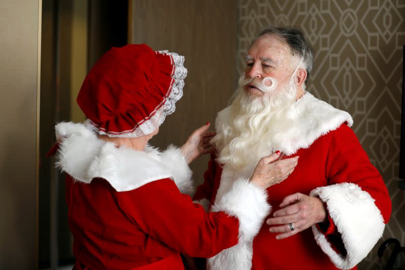 American couple Fred and Kathleen Honerkamp, make adjusts to their Santa Claus outfits as they prepare to visit Jerusalem's Old City together with a group of Santa Clauses from around the world, at their hotel in Jerusalem