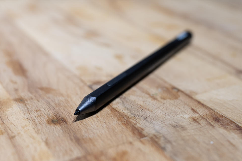 A black ASUS ZenScreen Ink MB14AHD monitor and accompanying stylus on a light wooden desk