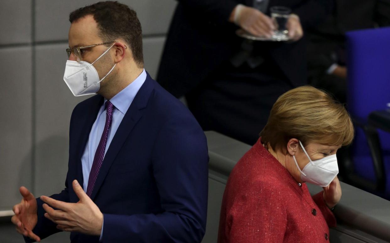 ens Spahn, Germanyâ€™s health minister, left, and Angela Merkel, Germany's chancellor, wear protective face masks in the Bundestag in Berlin, Germany, on Wednesday, Dec. 9, 2020. The debate about German spending has intensified as the country struggles to rein in its coronavirus outbreak.Â Photographer: Liesa Johannssen-Koppitz/Bloomberg - Liesa Johannssen-Koppitz/ Bloomberg