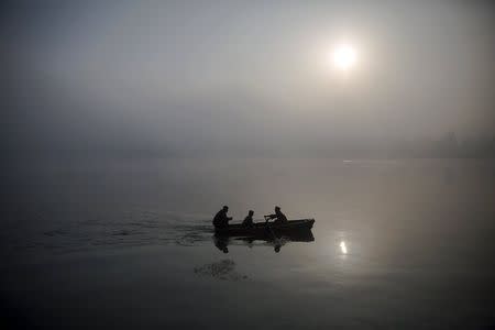 North Korean military personnel paddle a small boat amid morning fog over Taedong River in Pyongyang October 8, 2015. REUTERS/Damir Sagolj