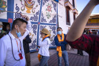 Tourists use earpieces to listen to a lecture at the Potala Palace in Lhasa in western China's Tibet Autonomous Region, Tuesday, June 1, 2021. Tourism is booming in Tibet as more Chinese travel in-country because of the coronavirus pandemic, posing risks to the region's fragile environment and historic sites. (AP Photo/Mark Schiefelbein)