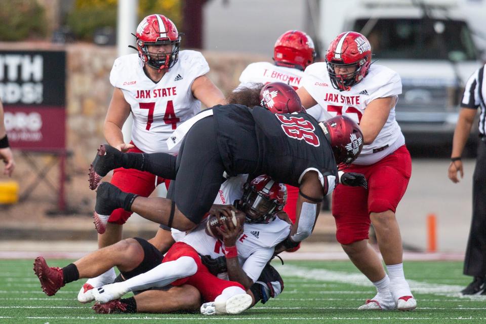 NMSU defensive tackle Izaiah Reed tackles a Jax State player during a NMSU football game on Saturday, Nov. 25, 2023, at the Aggie Memorial Stadium.