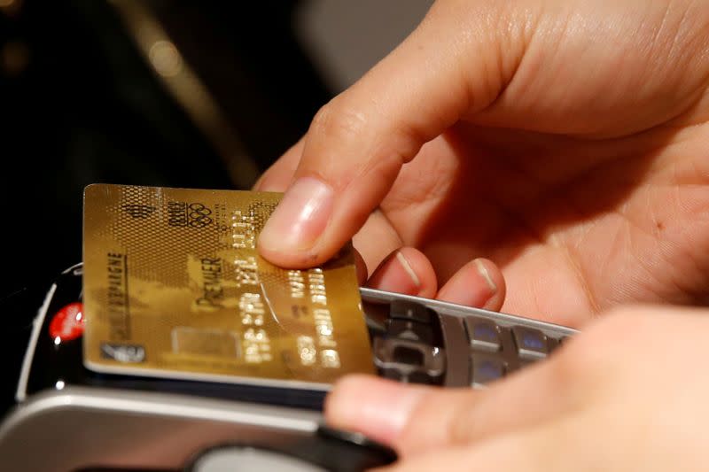 FILE PHOTO: A customer pays with a credit card at a store in Paris