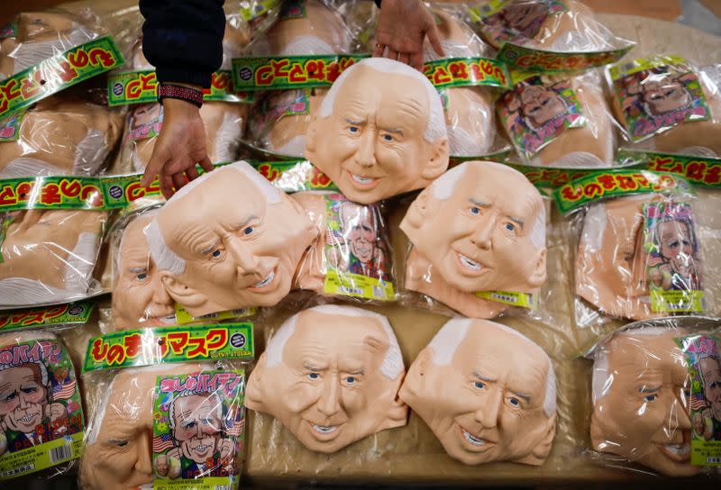 A worker of Ogawa Studios, a mask and toy making company, prepares to pack masks depicting U.S. President-elect Joe Biden in Saitama, Japan