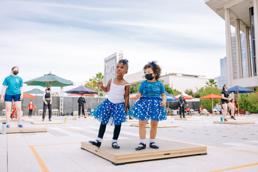 Two young girls in tutus try out their tap-dancing moves on the plaza at the Music Center in downtown L.A.