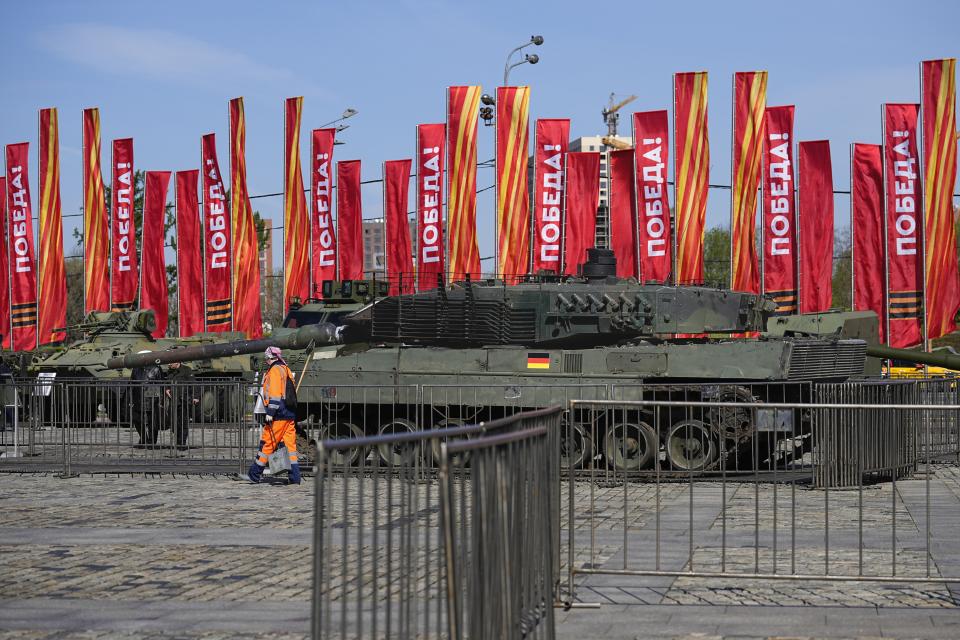 A municipal worker walks past a Leopard 2A6 tank that belonged to the Ukrainian army is seen on display in Moscow. Tuesday, April 30, 2024. The Russian military put some of the equipment captured from Ukrainian forces on display in Moscow. (AP Photo/Alexander Zemlianichenko)