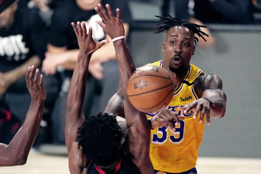 Los Angeles Lakers' Dwight Howard (39) passes the ball while pressured by the Miami Heat.
