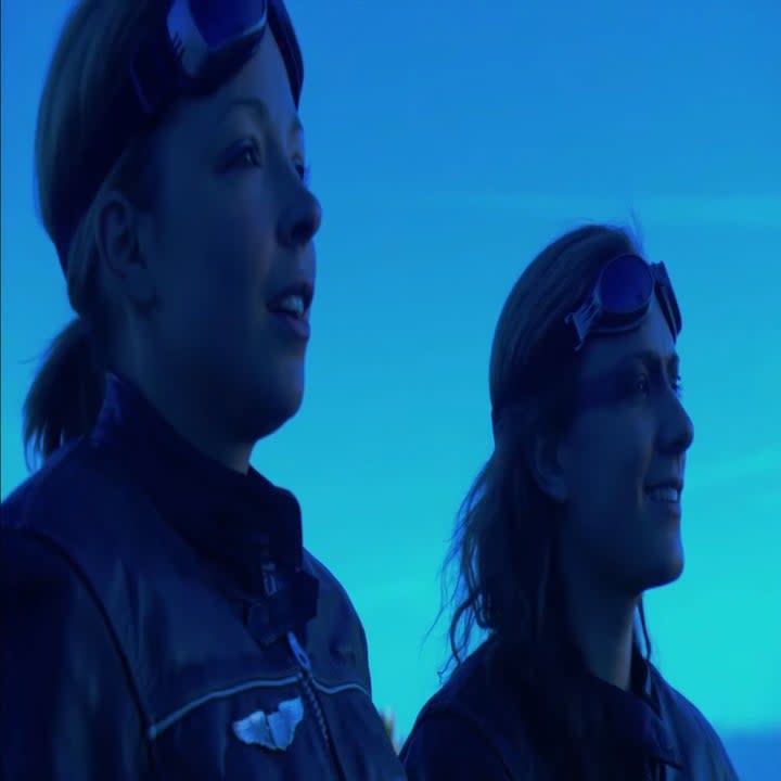 Two woman with goggles look into the distance