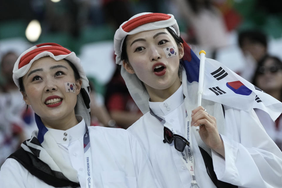 Hinchas de Corea del Sur animan antes de un partido del Grupo H del Mundial entre Corea del Sur y Portugal, en el estadio Education City en Rayán, Qatar, el 2 de diciembre de 2022. En un Mundial marcado por la controversia en lo político, no sorprende que el estilo de los aficionados haya suscitado polémica. En la primera Copa del Mundo que se celebra en Oriente Medio, aficionados de todo el mundo han reinterpretado los tocados y túnicas tradicionales de los países del Golfo Pérsico. (AP Foto/Hassan Ammar, archivo)