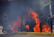 <p>Flames erupt as clashes break out near security forces members while the Constituent Assembly election is being carried out in Caracas, Venezuela, July 30, 2017. (Carlos Garcia Rawlins/Reuters) </p>