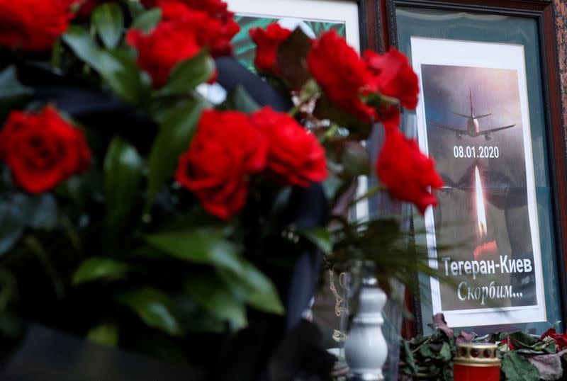 Flowers and a memorial poster are placed outside the Iranian Embassy to commemorate the victims of the Ukraine International Airlines flight PS752 plane crash