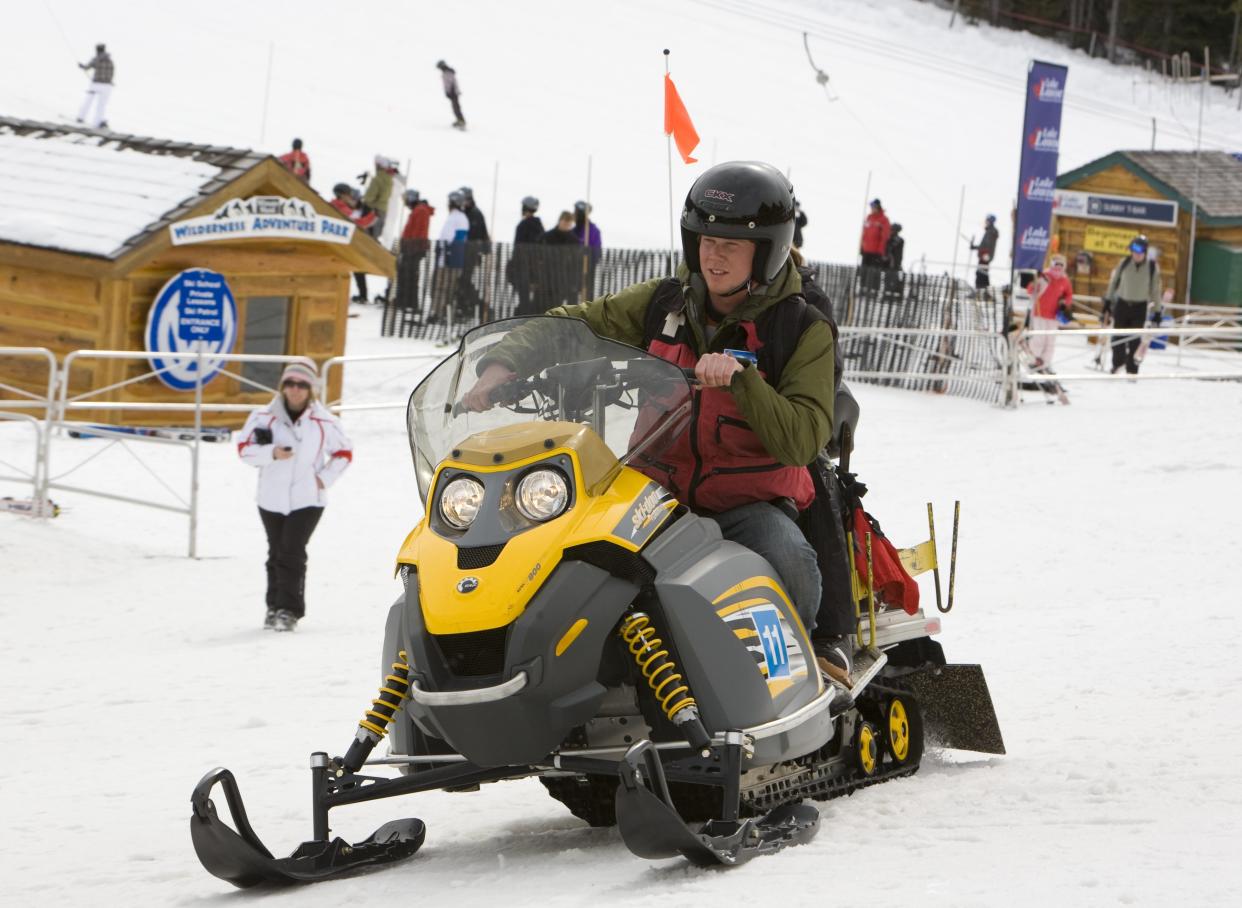 LAKE LOUISE, ALBERTA, CANADA - 2010:  A man on a snowmobile races past the lodge at Lake Louise Mountain Resort as seen in this 2010 Lake Louise, Canada, late morning photo. The resort will stay open later this year due to a heavy spring snowfall. (Photo by George Rose/Getty Images)